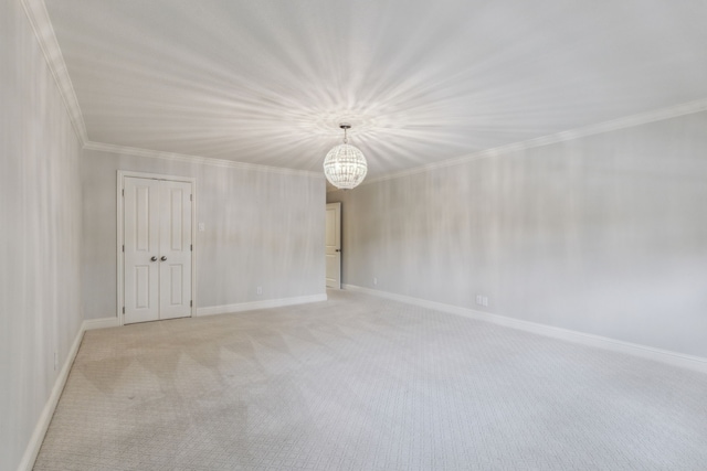 carpeted spare room with crown molding and a chandelier