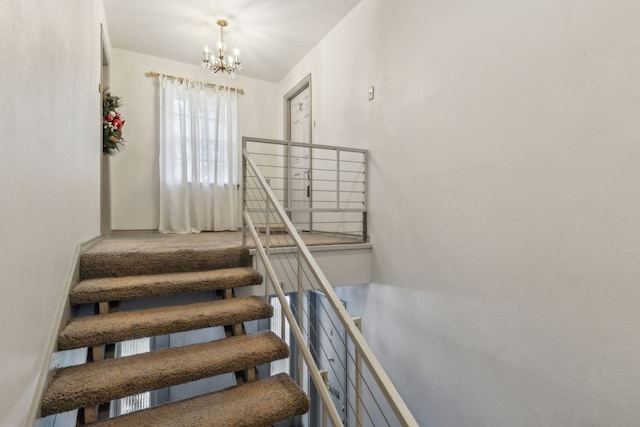 staircase featuring a chandelier