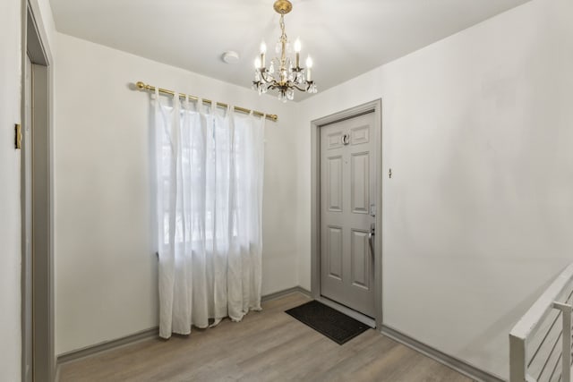 doorway featuring an inviting chandelier and light wood-type flooring