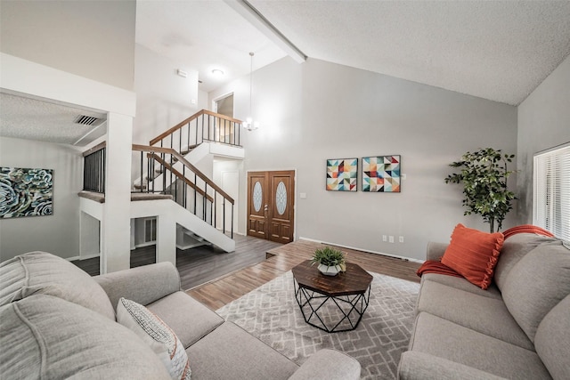 living room featuring beam ceiling, a textured ceiling, hardwood / wood-style flooring, and high vaulted ceiling