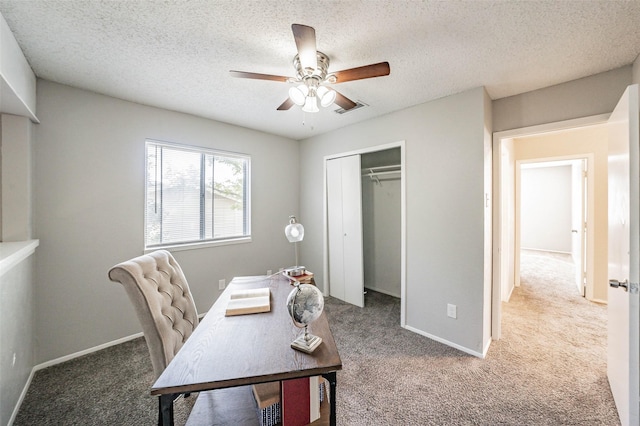 office featuring carpet flooring, ceiling fan, and a textured ceiling