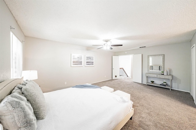 carpeted bedroom featuring a textured ceiling and ceiling fan