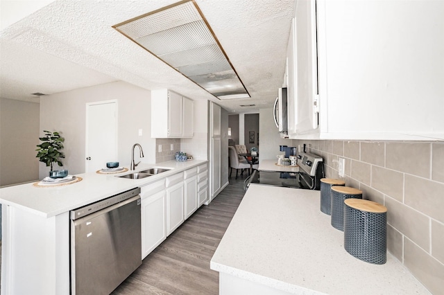 kitchen with white cabinets, appliances with stainless steel finishes, a textured ceiling, and sink