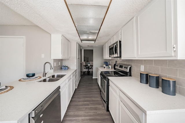 kitchen with appliances with stainless steel finishes, tasteful backsplash, white cabinetry, and sink