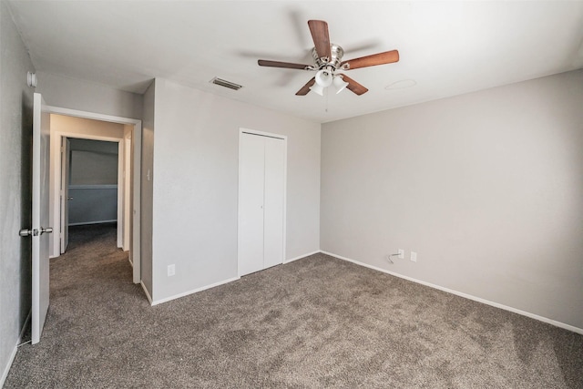 unfurnished bedroom with ceiling fan, a closet, and dark carpet