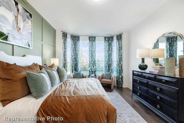 bedroom with multiple windows and dark wood-type flooring