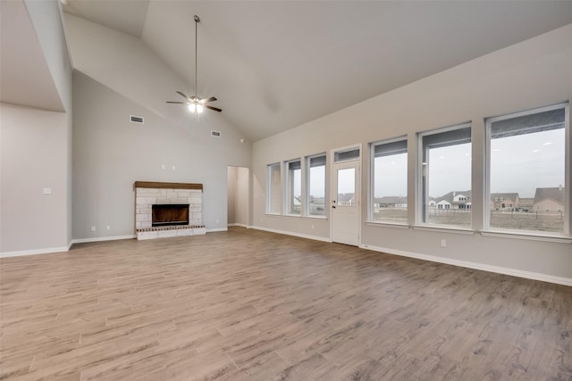 unfurnished living room featuring ceiling fan, light wood-type flooring, a fireplace, and lofted ceiling