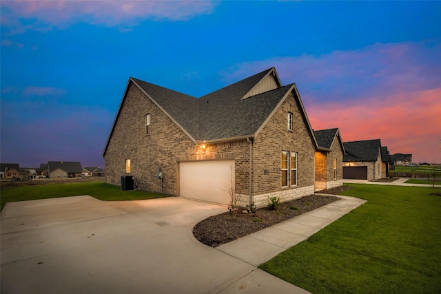 property exterior at dusk with a lawn and a garage