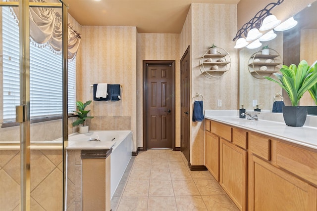 bathroom with tile patterned floors, a tub, plenty of natural light, and vanity