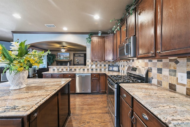 kitchen featuring decorative backsplash, dark wood-type flooring, stainless steel appliances, and sink