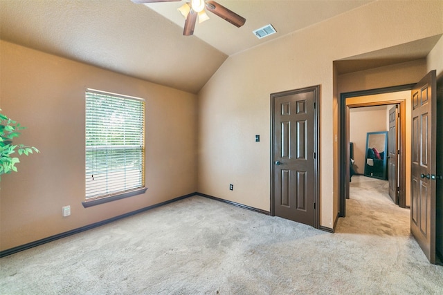 unfurnished room featuring ceiling fan, light colored carpet, and lofted ceiling