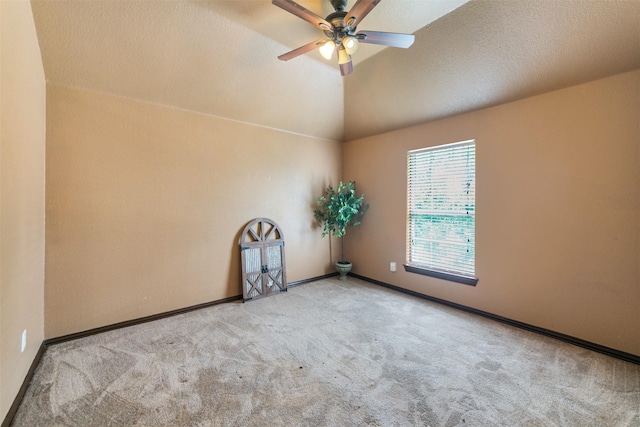 spare room featuring a textured ceiling, ceiling fan, light colored carpet, and vaulted ceiling