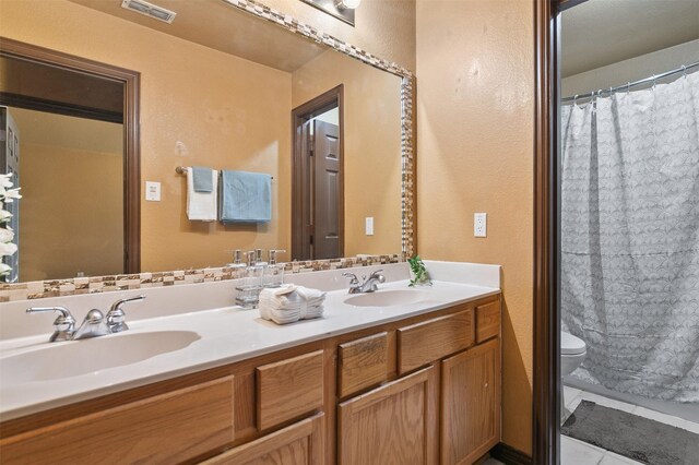 bathroom with tile patterned floors, vanity, and toilet