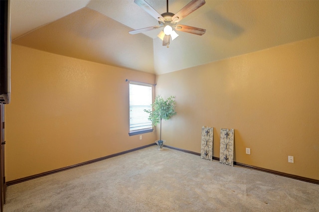 carpeted spare room with ceiling fan and lofted ceiling