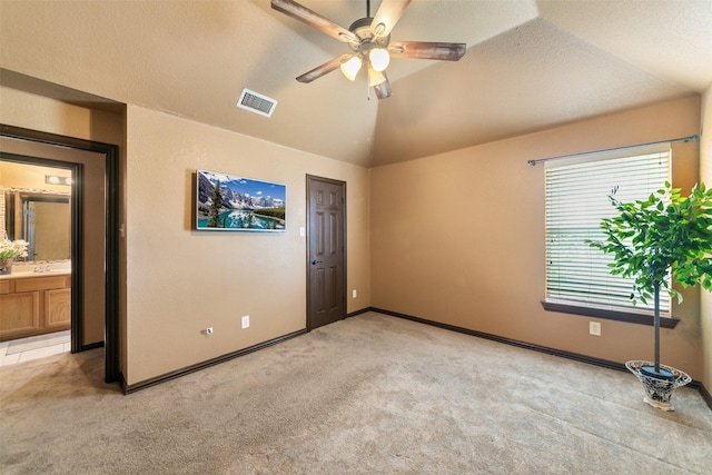 spare room featuring a textured ceiling, light carpet, ceiling fan, and lofted ceiling