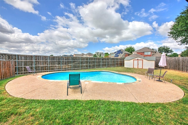 view of pool featuring a yard, a patio, and a shed