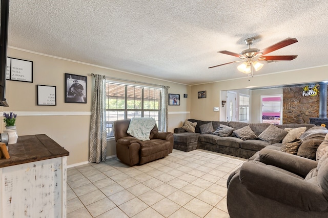 tiled living room with a textured ceiling, a wood stove, a wealth of natural light, and ceiling fan