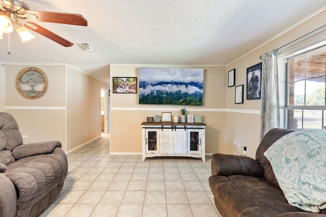 living room with a textured ceiling, ceiling fan, and light tile patterned flooring