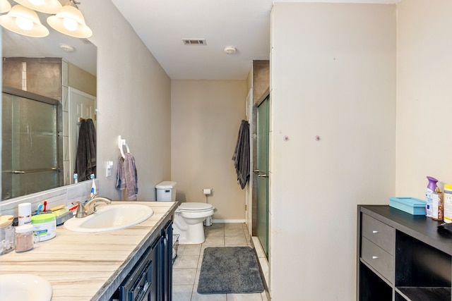 bathroom with tile patterned floors, toilet, vanity, and walk in shower