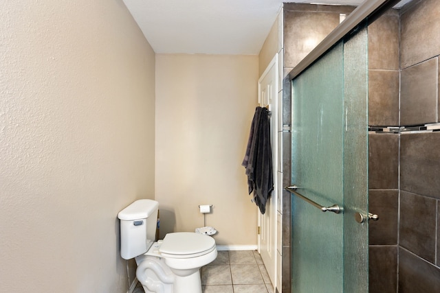 bathroom with tile patterned flooring, toilet, and a shower with shower door