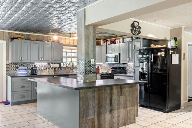 kitchen with a kitchen island, black appliances, light tile patterned floors, and ornamental molding