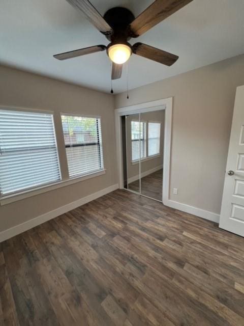 unfurnished bedroom with dark hardwood / wood-style flooring, ceiling fan, and a closet