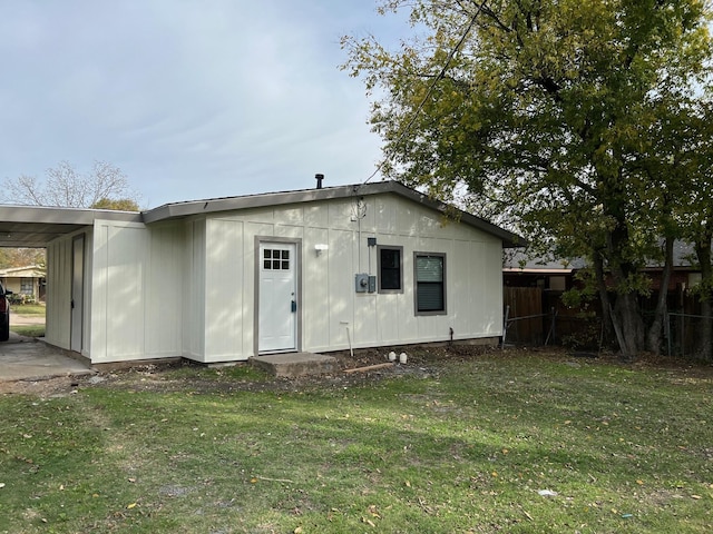 back of house featuring a lawn and a carport