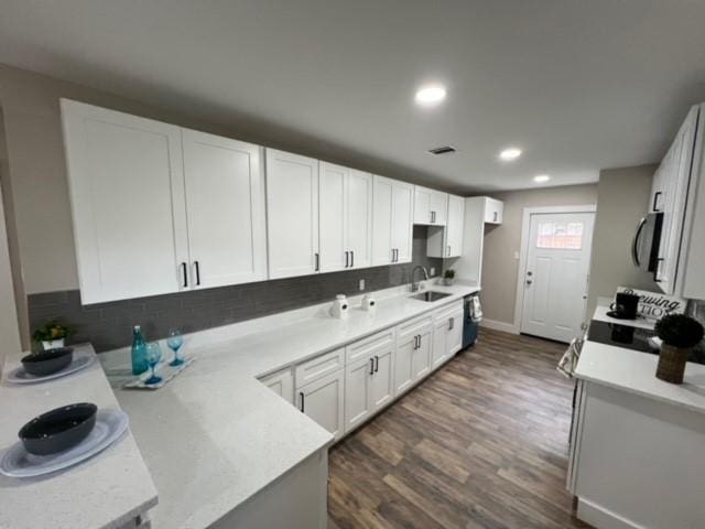232 Alto Dr, Garland, TX 75040 - kitchen with white cabinets, dark wood finished floors, light countertops, and a sink