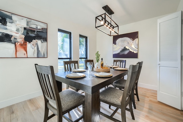 dining room with light hardwood / wood-style floors and a chandelier