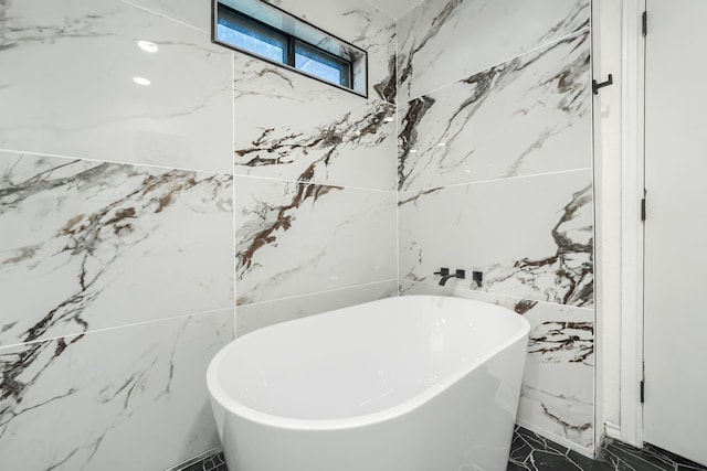 bathroom with a bathing tub and tile walls