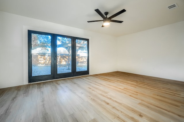 empty room with ceiling fan and light hardwood / wood-style flooring