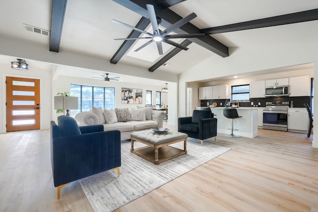 living room with ceiling fan, sink, beamed ceiling, high vaulted ceiling, and light wood-type flooring