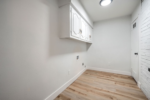 laundry area with electric dryer hookup, cabinets, hookup for a washing machine, and light hardwood / wood-style flooring