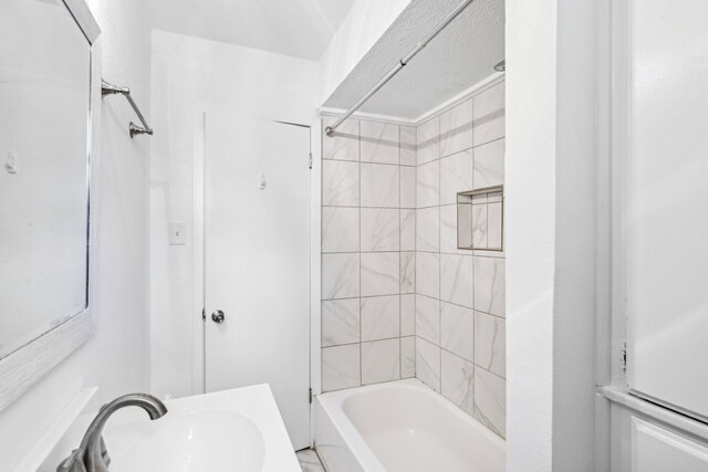 bathroom featuring tiled shower / bath and sink