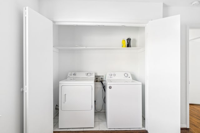 washroom with separate washer and dryer and light tile patterned floors