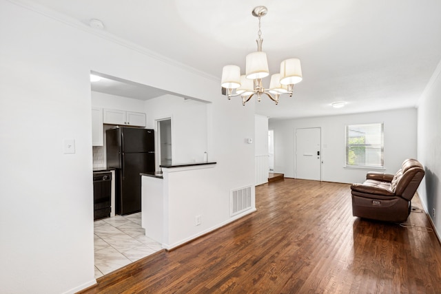 unfurnished living room featuring light hardwood / wood-style flooring and a chandelier