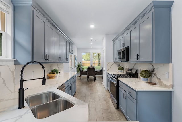 kitchen with appliances with stainless steel finishes, tasteful backsplash, and light stone counters