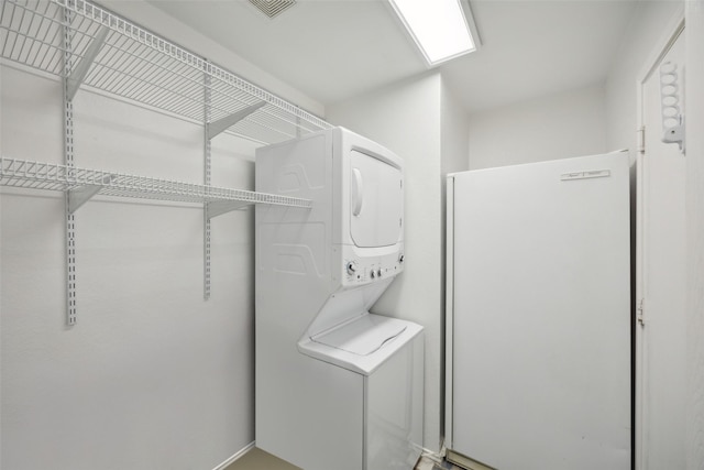 clothes washing area with stacked washer and dryer