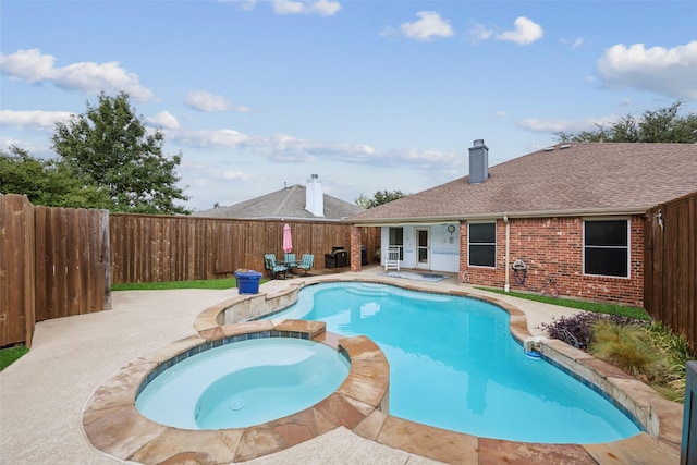 view of pool with an in ground hot tub and a patio area