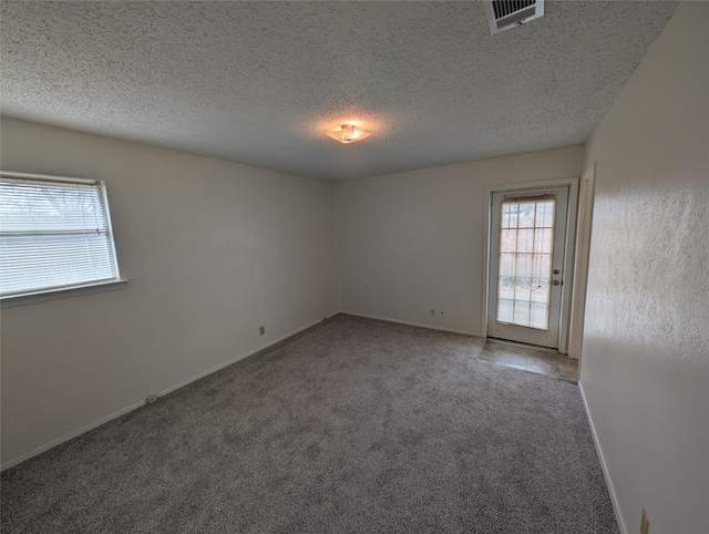 spare room featuring carpet and a textured ceiling