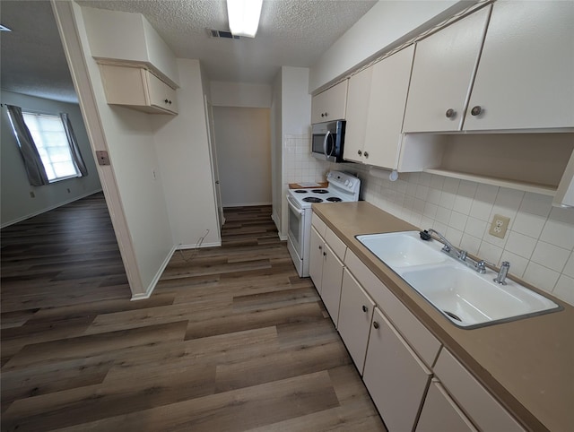 kitchen with backsplash, white cabinets, electric stove, sink, and hardwood / wood-style flooring