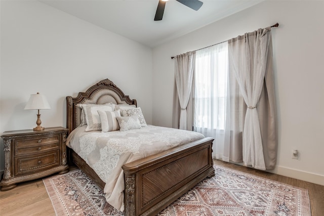 bedroom featuring ceiling fan, light wood-type flooring, and multiple windows