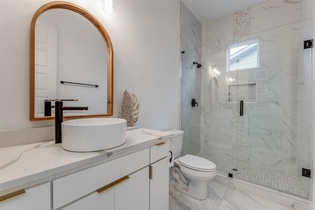 bathroom featuring a shower with door, vanity, and toilet