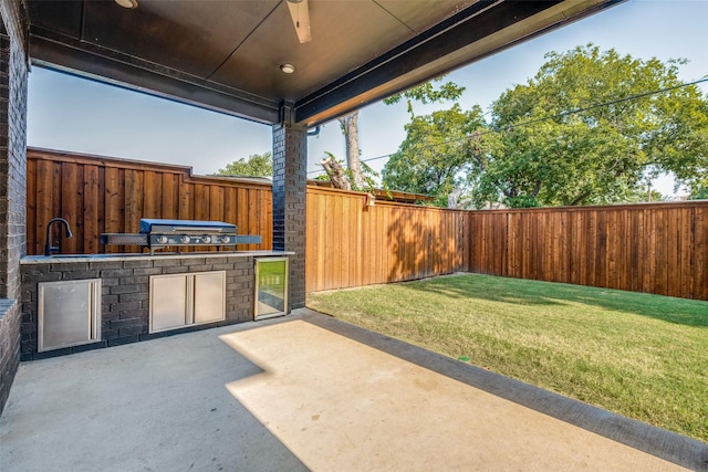 view of patio featuring a grill, ceiling fan, sink, and an outdoor kitchen