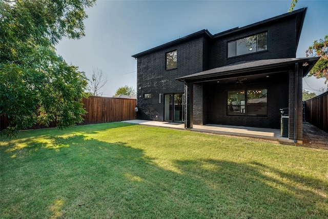 rear view of house with a yard and a patio area