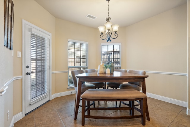 dining room featuring light tile patterned flooring and a notable chandelier