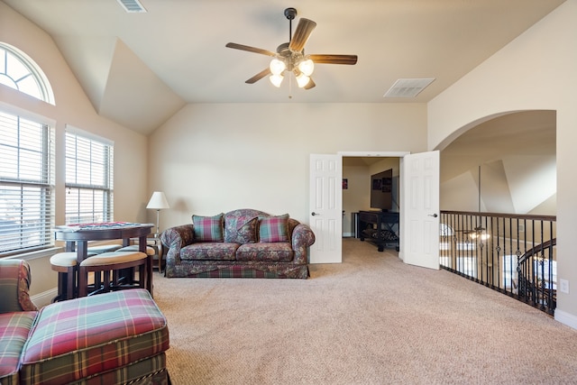 carpeted living room with ceiling fan and lofted ceiling