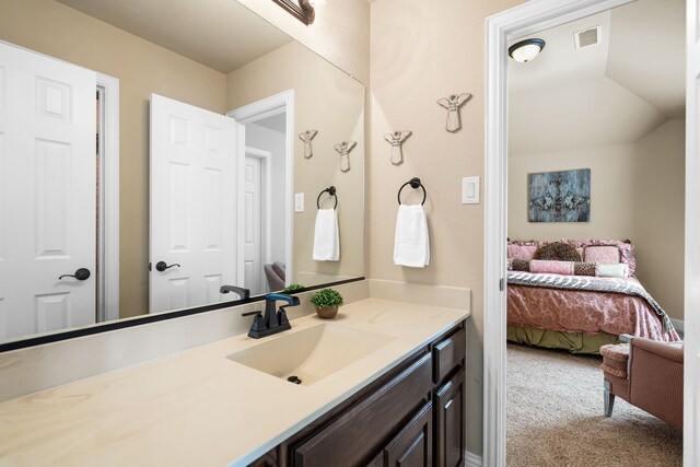 bathroom featuring vanity and lofted ceiling