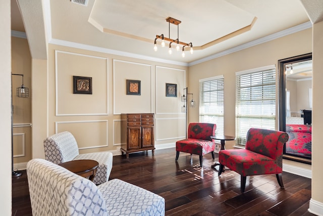 sitting room with dark wood-type flooring, crown molding, and a tray ceiling