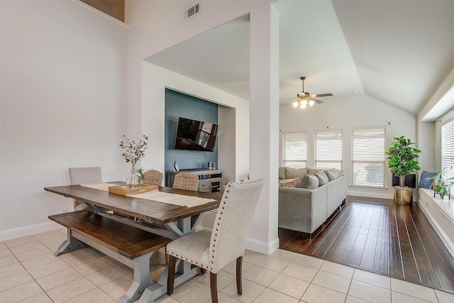 tiled dining area with ceiling fan and lofted ceiling